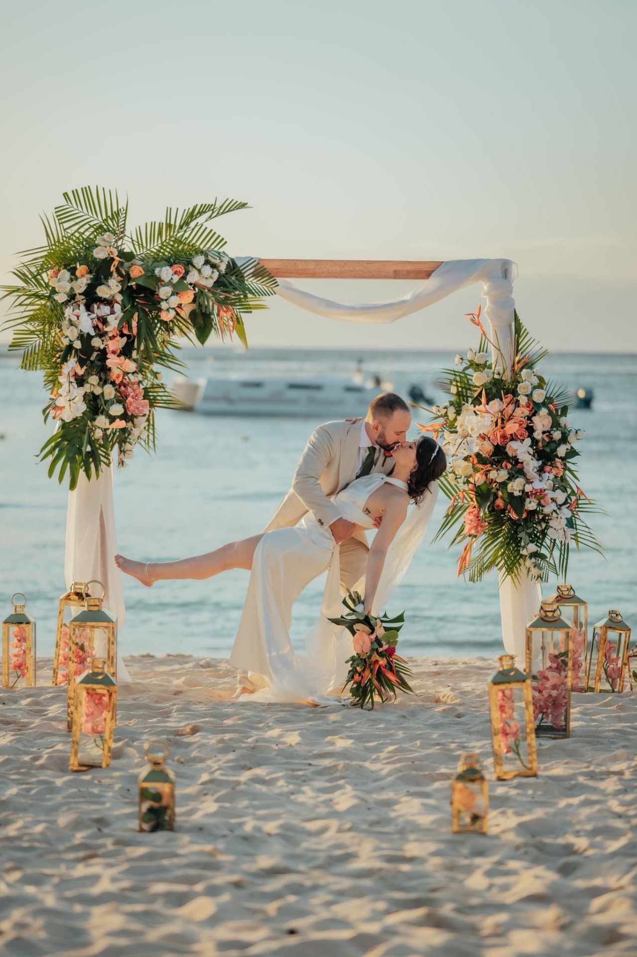 Couple at a tropical beach ceremony at golden hour